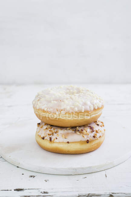Two iced doughnuts, piled - foto de stock