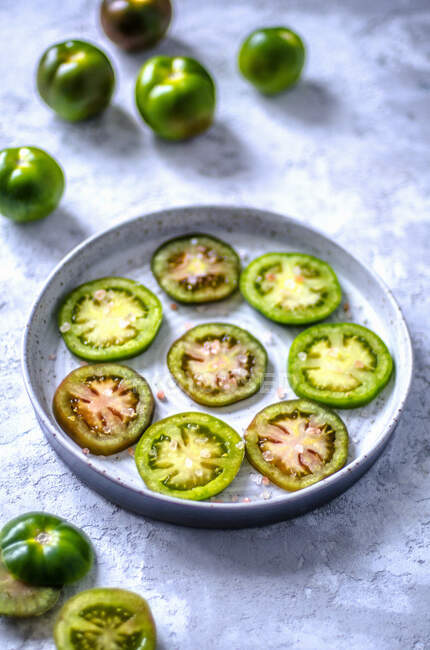 Ringed green tomatoes with large Himalayan salt — Stock Photo