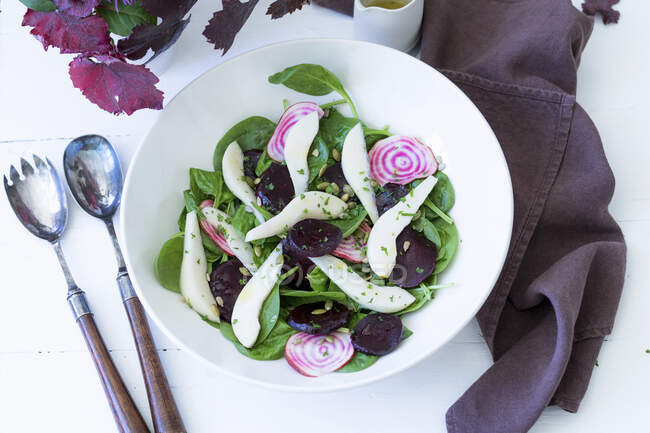Салат из груши и свеклы со шпинатом и соусом из винегрета — стоковое фото