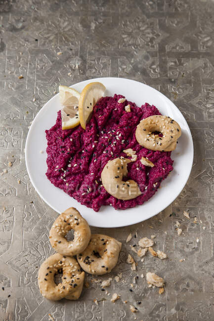 Beetroot hummus with sesame seed bread rings — Stock Photo