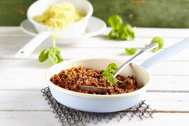 Classic bolognese sauce in a pan with a spoon — Stock Photo