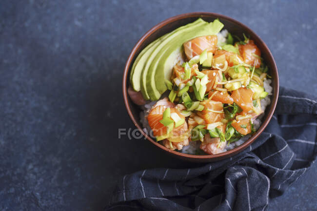 Poke-Schüssel mit rohem mariniertem Lachs, Gurken und Avocado — Stockfoto