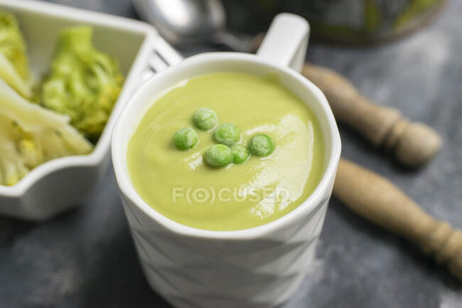 Pea soup, closeup of white cup — Stock Photo