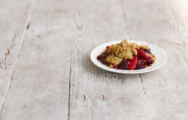 Apple and blackberry crumble on a plate — Stock Photo