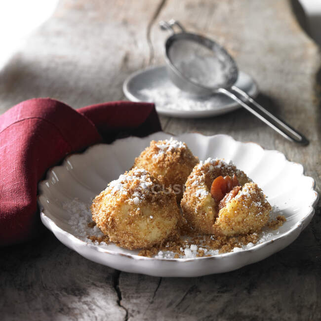 Damson dumplings roasted in butter with breadcrumbs and icing sugar — Stock Photo