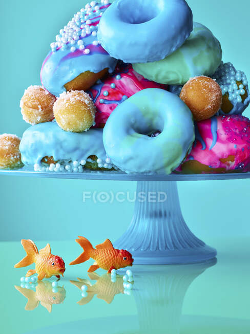 Ciambelle colorate su uno stand di torta — Foto stock