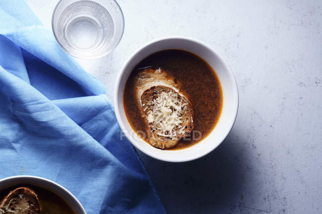 Due ciotole di zuppa vegetariana calda servite con crostini e parmigiano — Foto stock