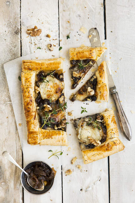 Goat's cheese and caramelised onion tart topped with walnuts and thyme — Stock Photo