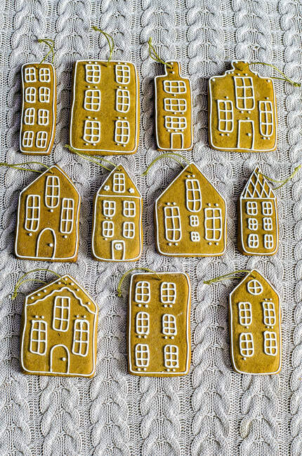 Maisons en pain d'épice avec cordes dorées sur la surface tricotée — Photo de stock