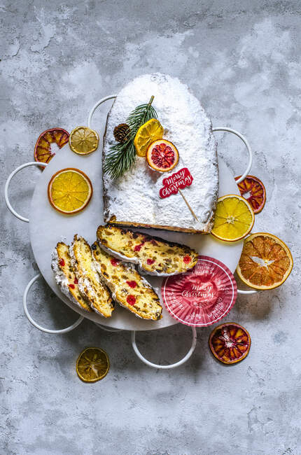 Christmas stollen on an openwork stand with citrus chips, decorated in a Christmas design — Stock Photo