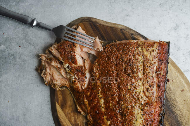 Smoked salmon with pepper on wooden cutting board — Stock Photo