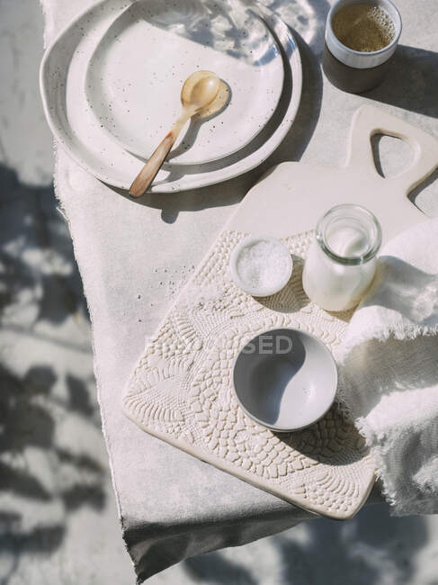 Plats en céramique, sel et lait sur une table — Photo de stock