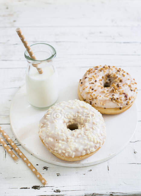 Donuts com leite na mesa de madeira — Fotografia de Stock
