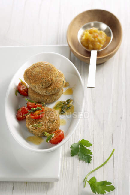 Baked amaranth and cheese rounds with a mango dip and cherry tomatoes — Stock Photo