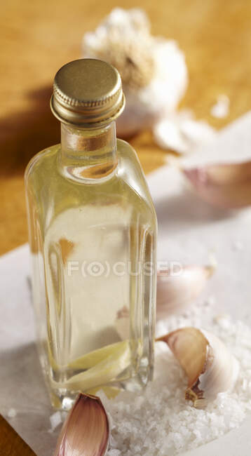 Домашний чесночный уксус с морской солью в стеклянной бутылке — стоковое фото