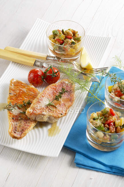 Roasted red mullet with amaranth and vegetables in glasses — Stock Photo