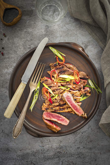 Жареный говяжий стейк посыпанный чили и весенним луком — стоковое фото