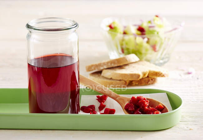 Homemade sour cherry vinegar in a glass, with salad and white bread — Stock Photo