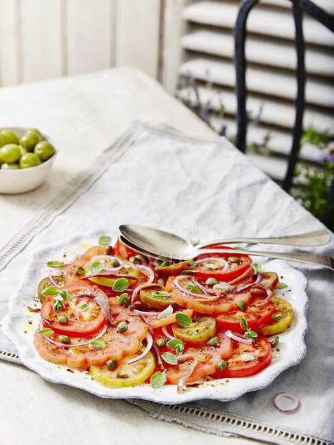 Salada de tomate e cebola com alcaparras servidas com azeitonas — Fotografia de Stock