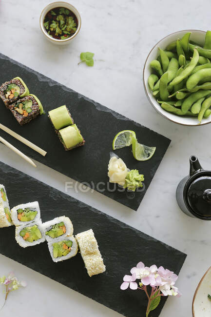 Vari tipi di sushi con fagioli edamame in ciotola — Foto stock