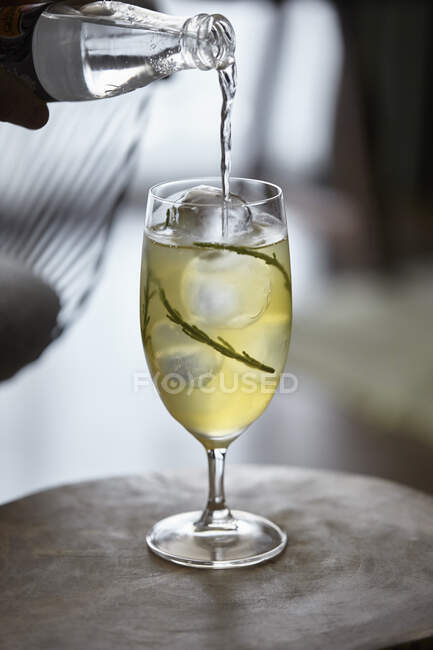 A samphire and tonic cocktail being poured — Stock Photo