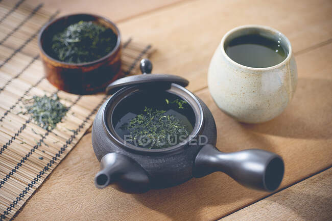 Té verde en una olla y una taza - foto de stock