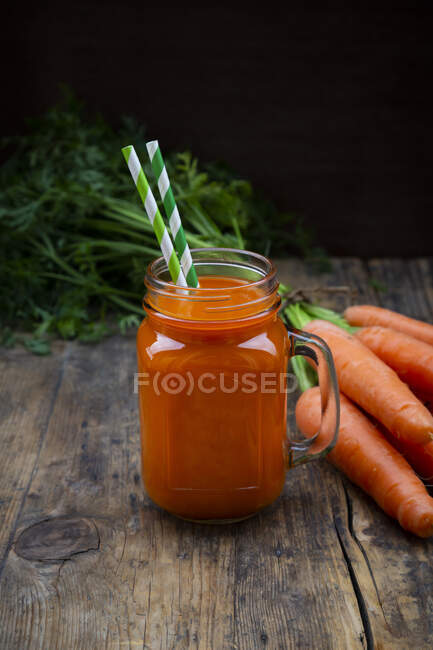 A carrot smoothie with straws in a tankard — Stock Photo
