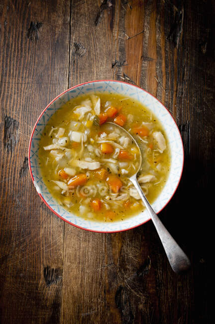Soup with chicken and vegetables on a wooden background — Stock Photo