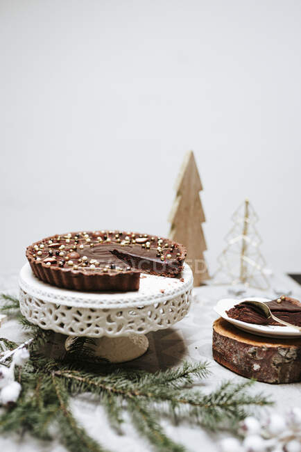 Pasteles de chocolate en un pastel se coloca en una mesa decorada para Navidad - foto de stock