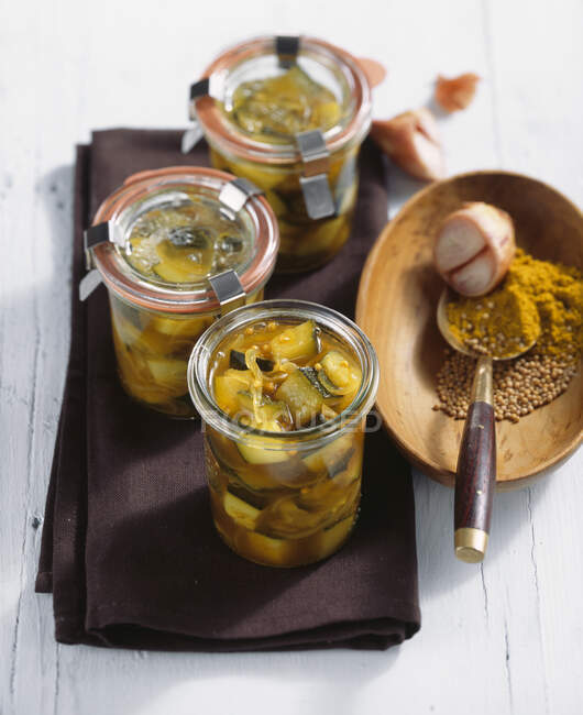 Pickled curried courgette in white wine vinegar, peppers and mustard in jars — Stock Photo