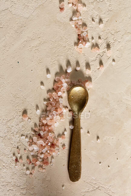 Розовая гималайская соль на золотой ложке — стоковое фото