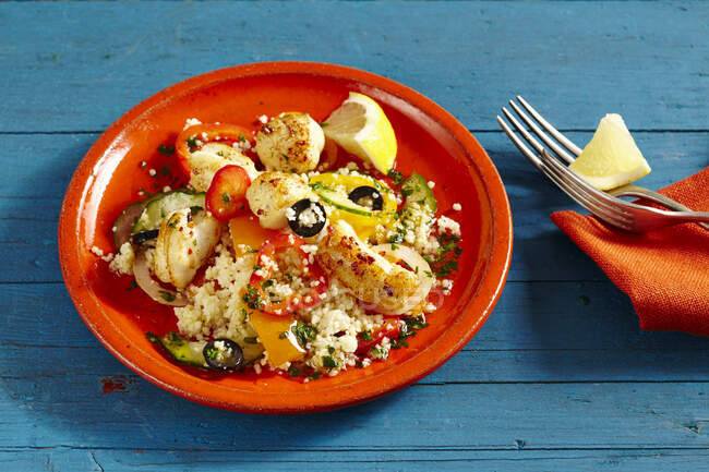Couscous salad with fried fish and olives — Stock Photo