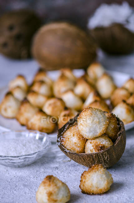 Biscoitos de coco em casca de coco e na placa — Fotografia de Stock