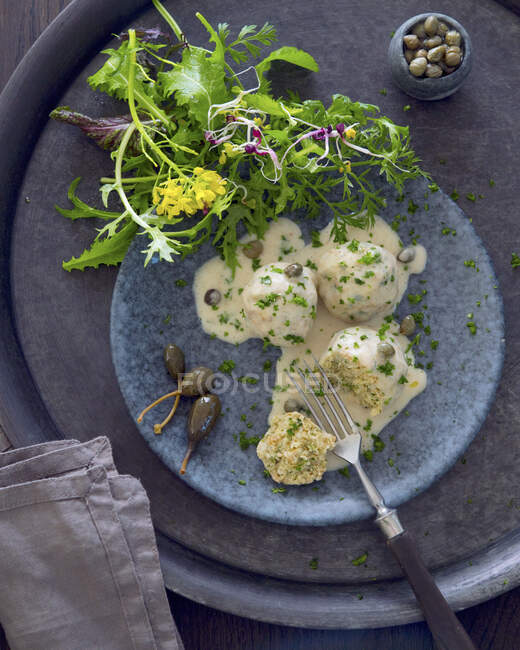 Пельмени из вегетарианского зерна с каперским соусом и салатом — стоковое фото