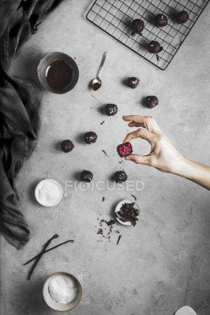 Mani femminili in grembiule nero con bacche e cioccolato — Foto stock