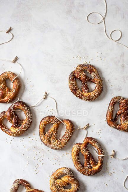 Homemade pretzels with seasme seeds on a string — Stock Photo