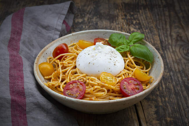 Spaghetti with pesto rosso, cherry tomatoes and burrata — Stock Photo