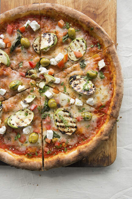 Feta und Gemüsepizza auf einem Holzbrett — Stockfoto