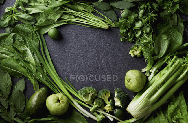 Різноманітність зелених овочів і фруктів на темному бетонному фоні — стокове фото