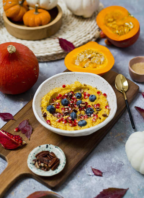 Millet and pumpkin porridge, served with pomegranate seeds and blueberries — Stock Photo