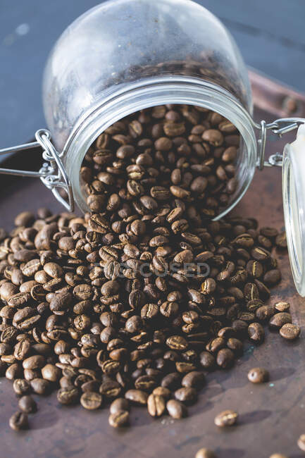 Кофейные зерна выпадают из стакана — стоковое фото