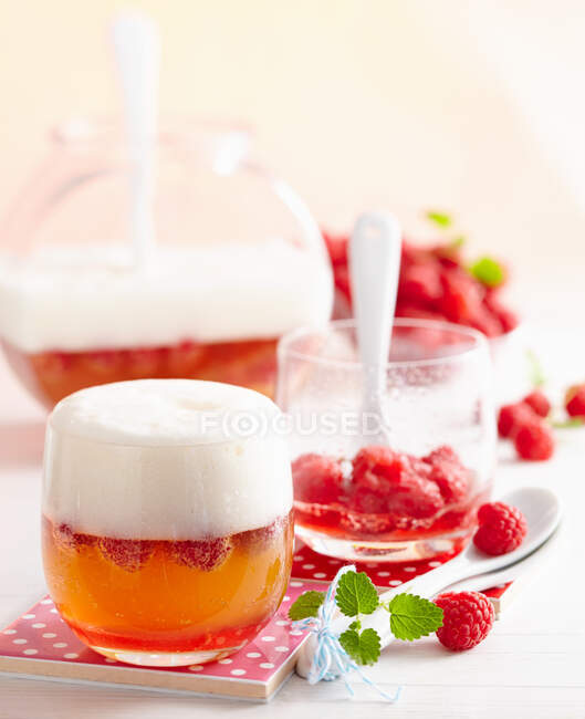 Wheat peach punch with raspberries in glasses and jar — Stock Photo