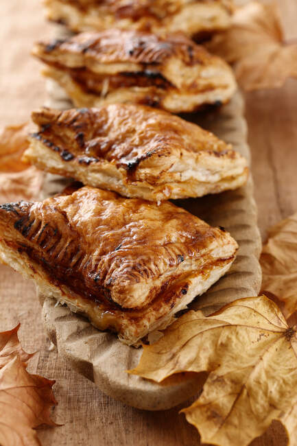 Apple pies with puff pastry and autumn leaves — Stock Photo