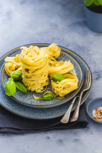 Pasta nests in blue bowl — Stock Photo