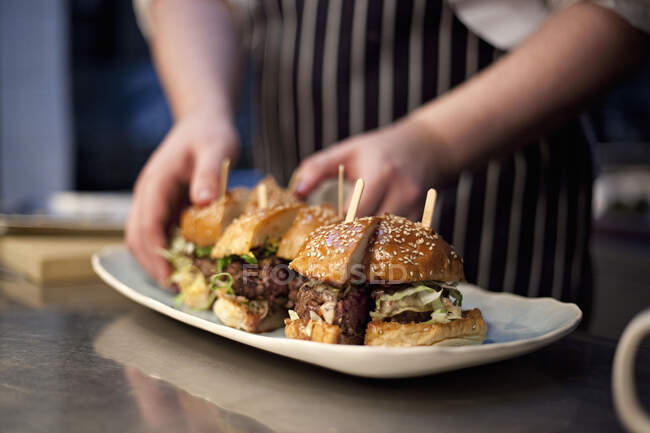 A chef plating up Burgers — Stock Photo