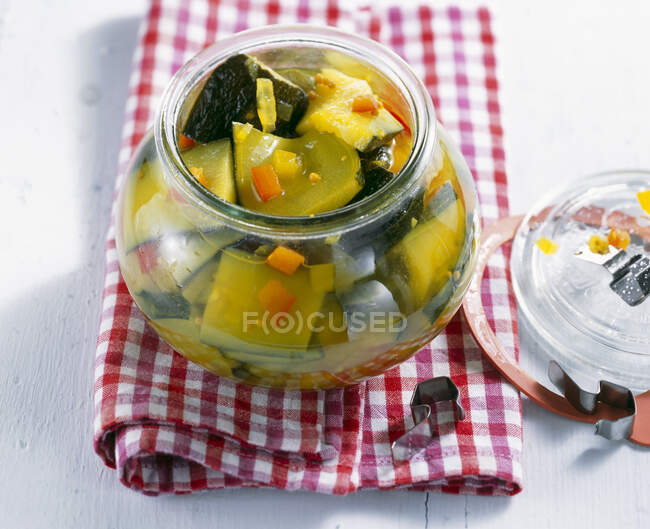 Pickled courgettes with turmeric and mustard seeds in a jar — Stock Photo