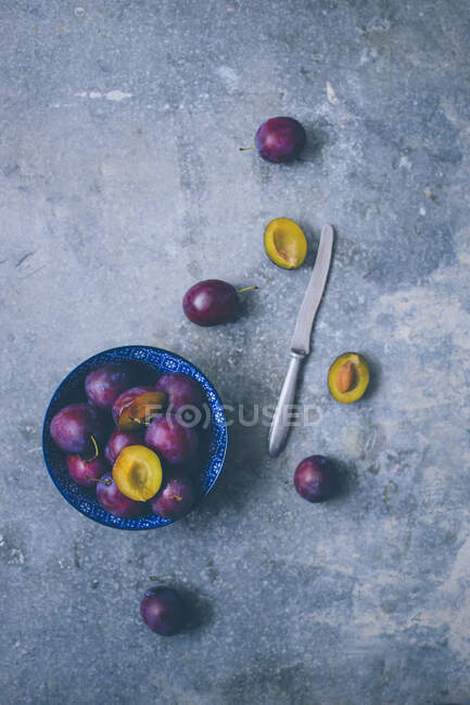 Fresh damsons, partially halved and pitted (seen from above) — Stock Photo