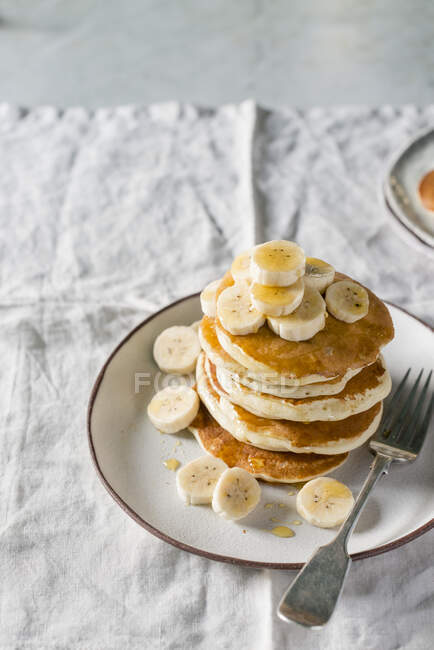 Stack of banana pancakes with fresh banana slices — Stock Photo