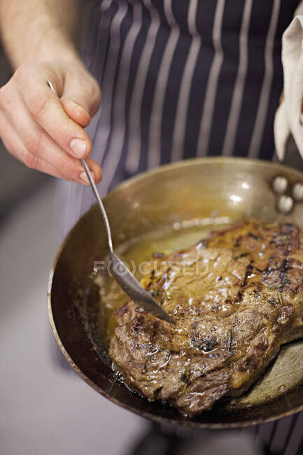 Steak being basted with butter in a pan — Stock Photo