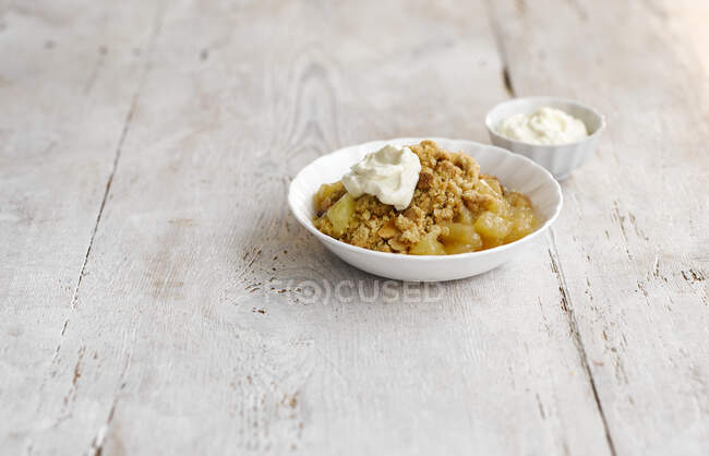 Apple crumble with calvados served with cream — Stock Photo
